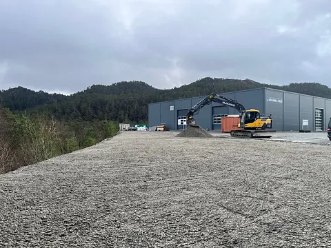 Gul gravemaskin på byggeplass