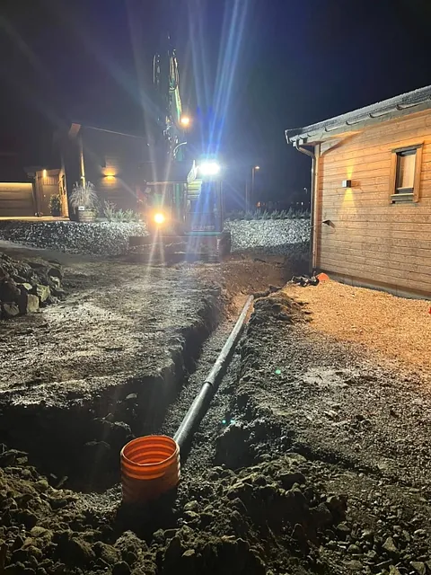 Dreneringsgrøft på tomt ved hvitt hus